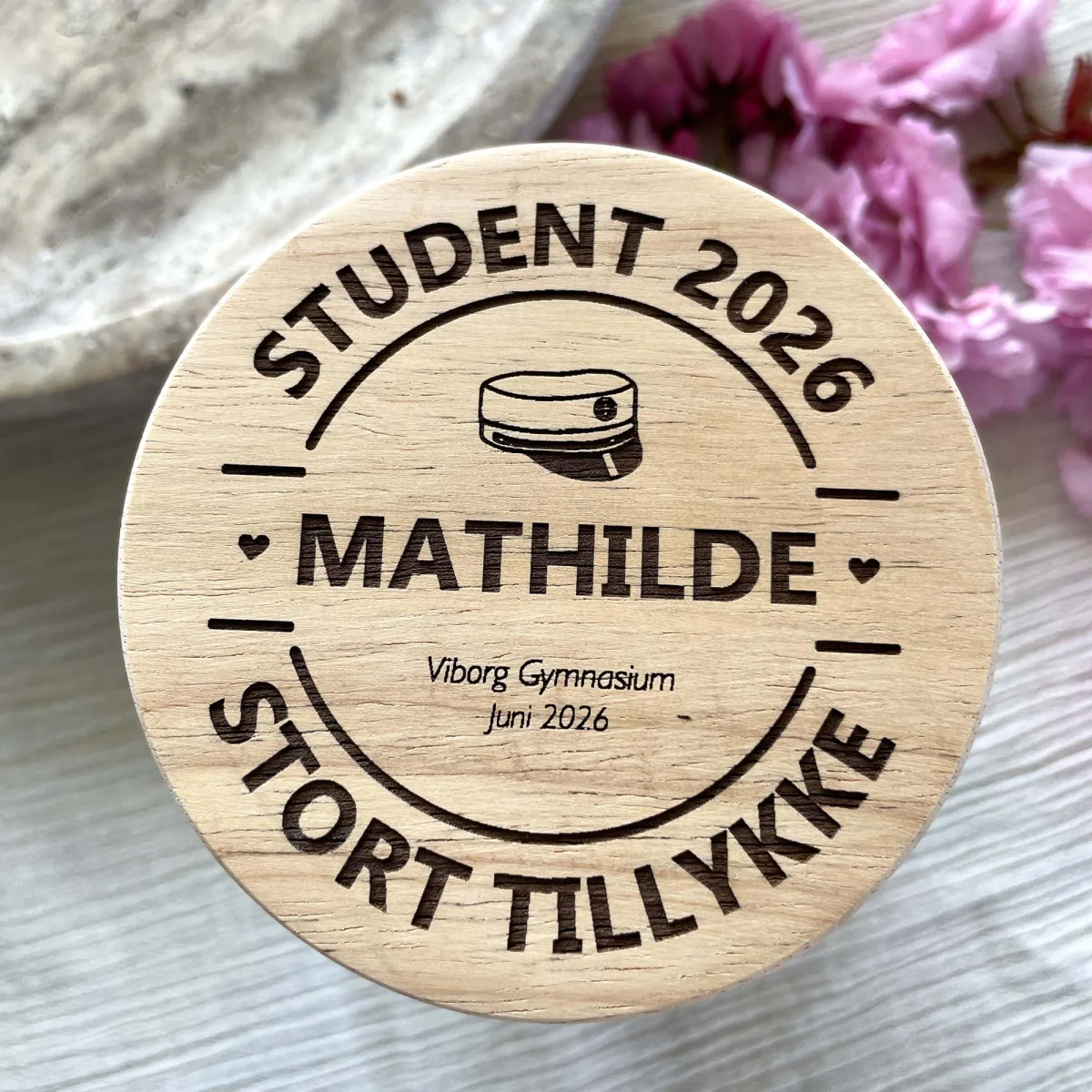 Studentergave: krukke i glas med trælåg, indgraveret studenterhue, navn og dato