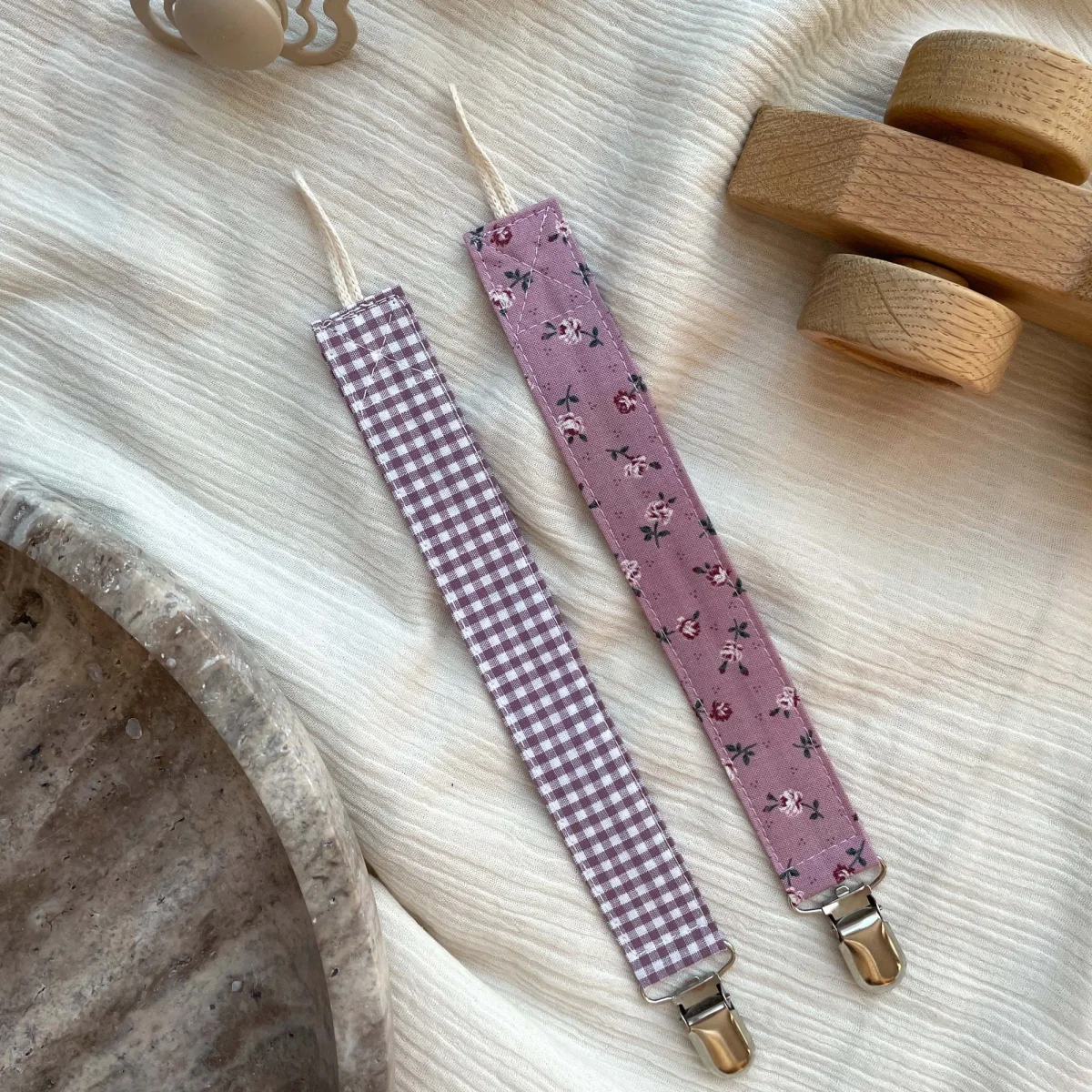 To suttesnore i rosa nuancer, en med tern og en med blomsterprint